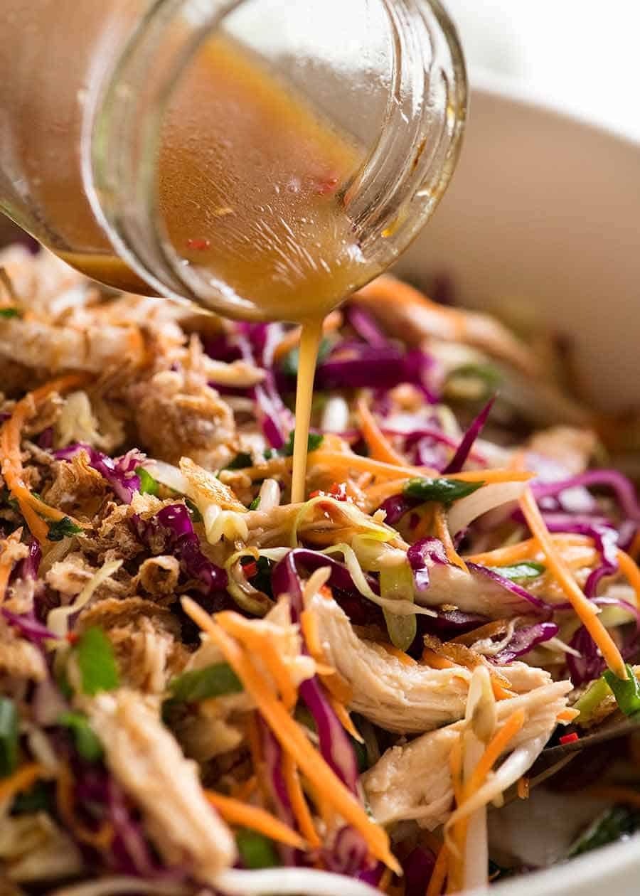 Pouring Asian dressing over Asian Slaw