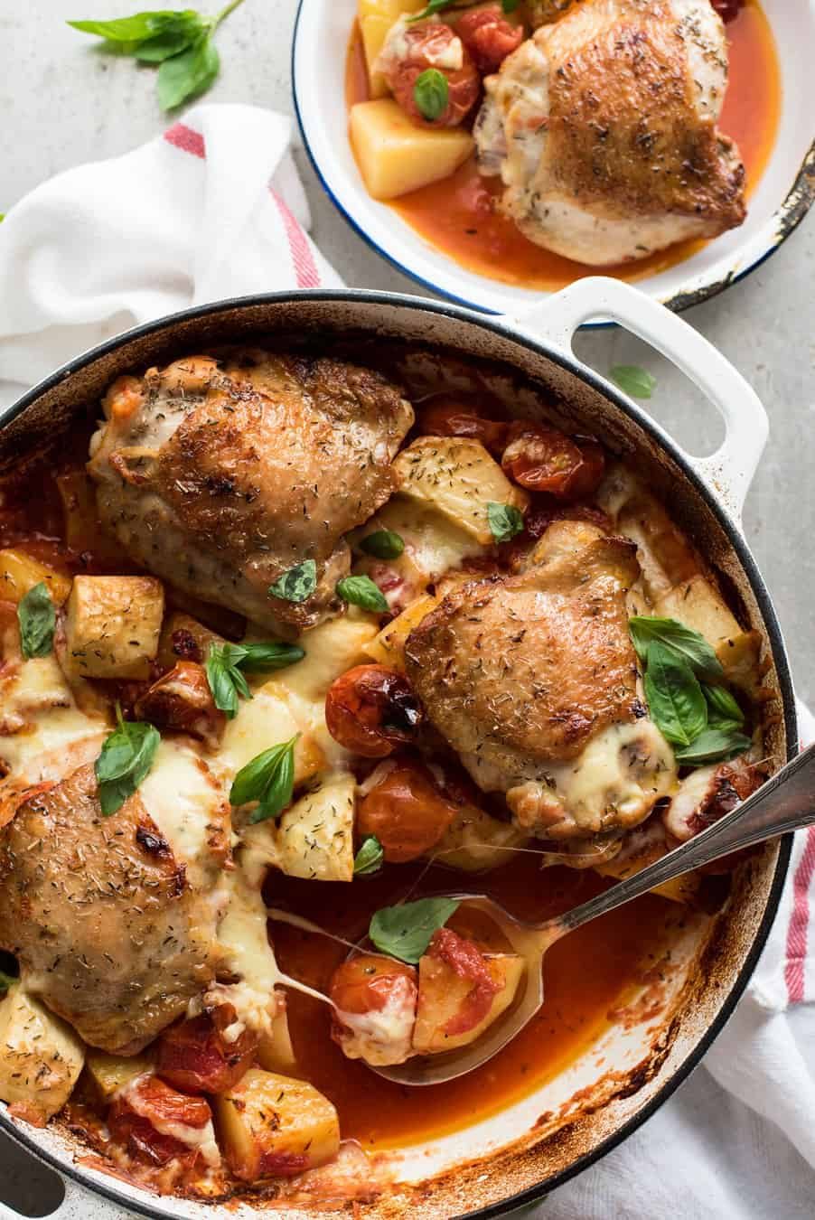Baked Italian Chicken with Potatoes in a white casserole dish, fresh out of the oven ready for serving.