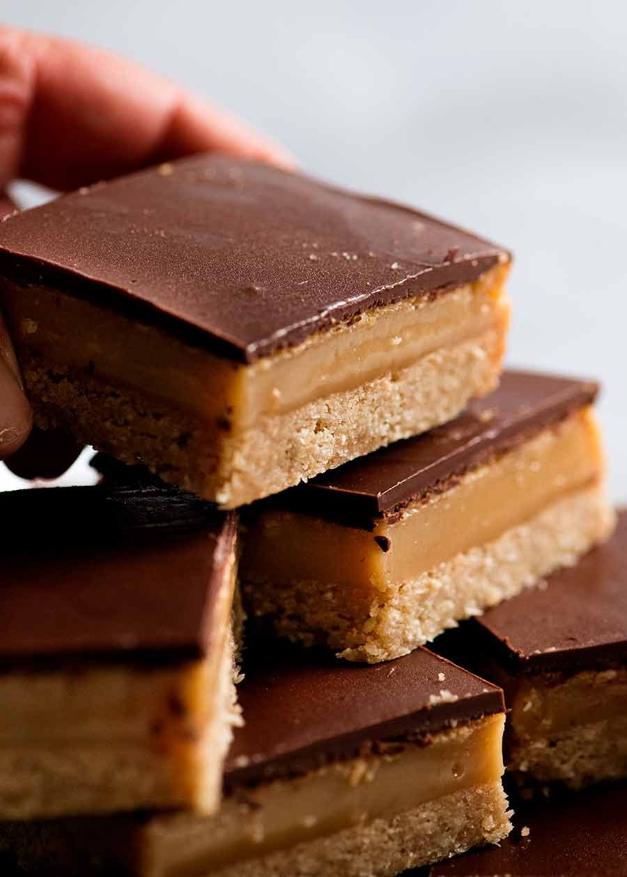 Close up of hand picking up Caramel Slice