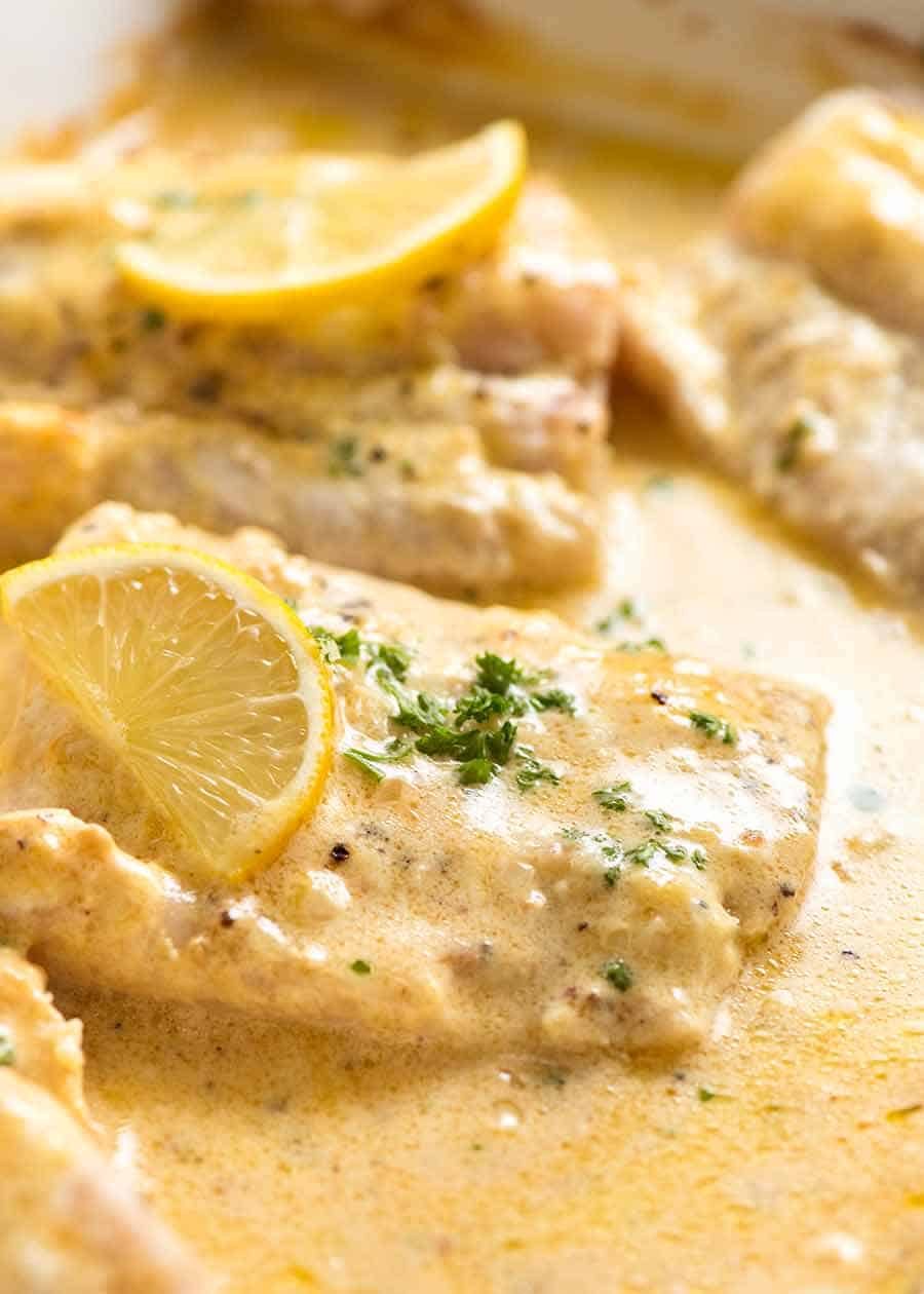 Close up photo of Baked Fish with Lemon Cream Sauce in a white pan, fresh out of the oven