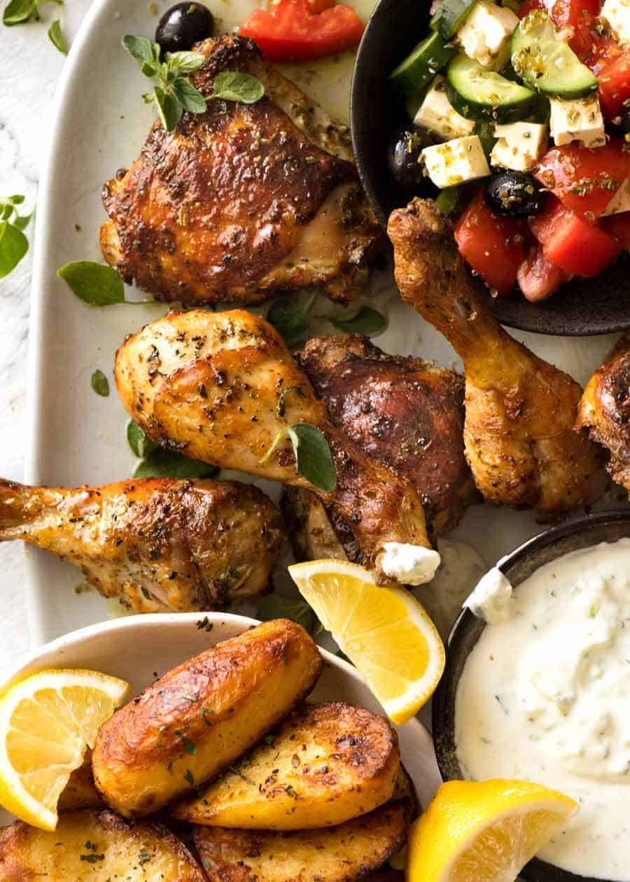 Greek Chicken on a plate with Greek Salad, Lemon Roasted Potatoes and Tzatziki on the side