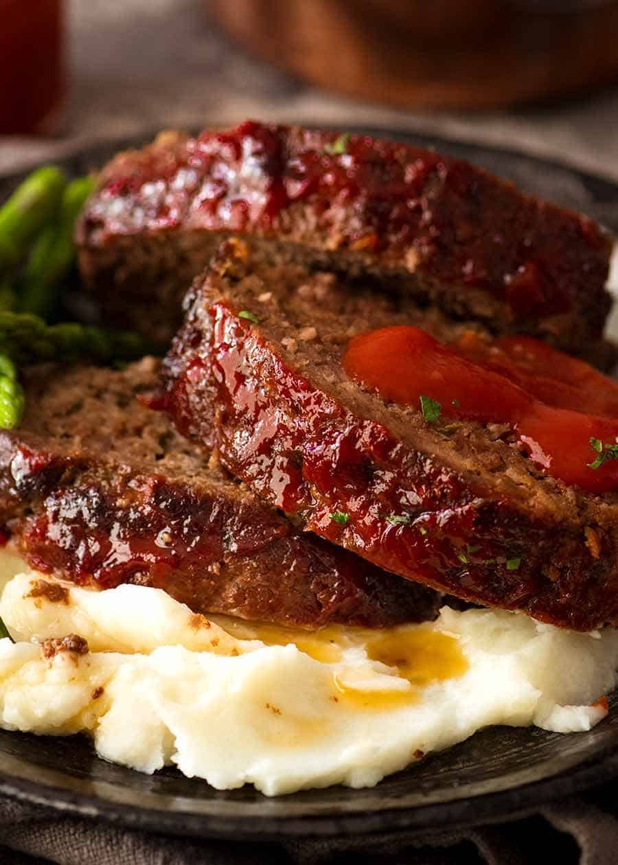 Close up of Meatloaf recipe - slices served over mashed potato with ketchup