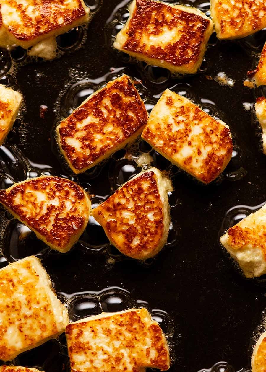 Paneer being pan fried in a skillet